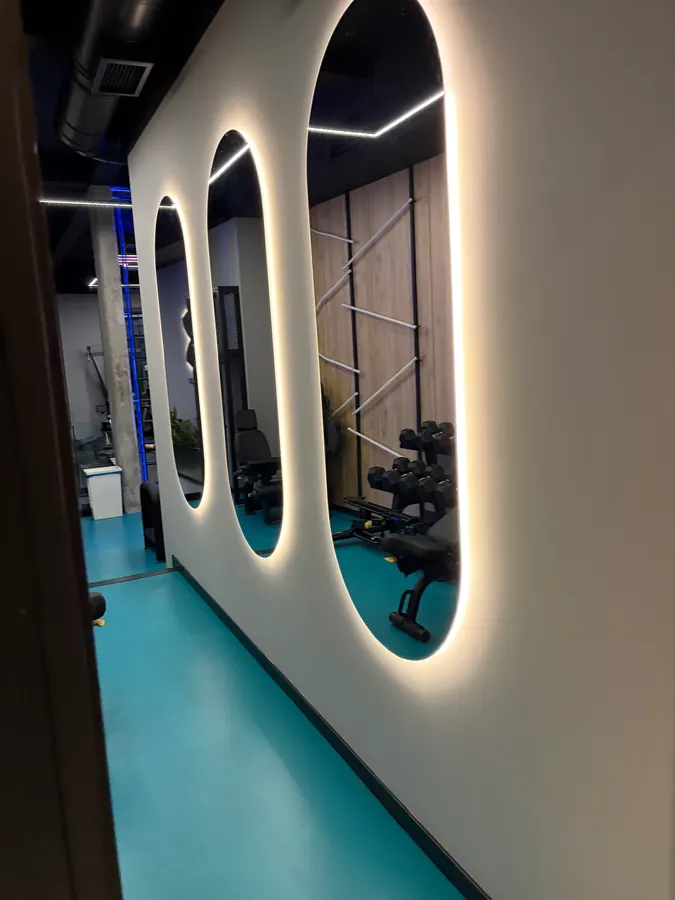 Λευκές φωτεινές καμάρες στον τοίχο και το aqua δάπεδο