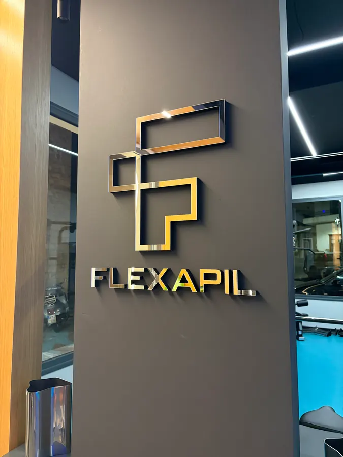 Το χρυσό μονόγραμμα Flexapil στον τοίχο της εισόδου